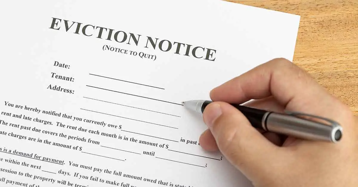 hand-ready-to-fill-a-eviction-notice-document-wv-magistrate-court-forms-frequent-court-forms The hand of a person holds a pen ready to sign an eviction notice, which is a frequent court form among the WV Magistrate Court forms.